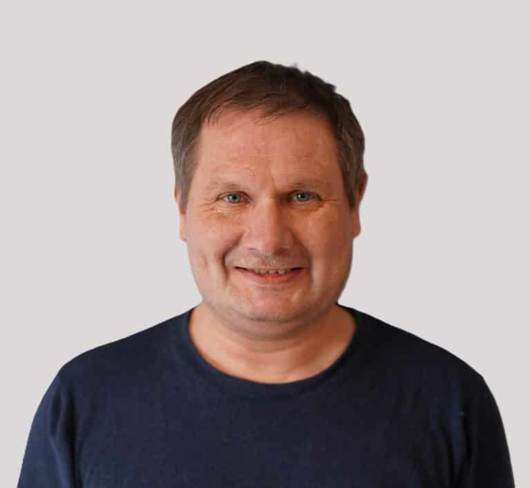 Person i svart genser som smiler mot kamera.