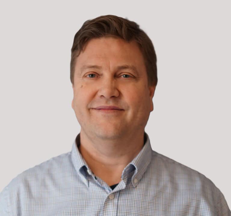 Modell av en profesjonell mann i forretningskontor, smilende, i skjorte.