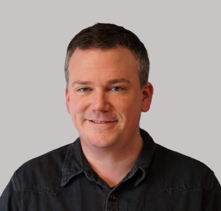 Profesjonell mann i svart skjorte smiler for kamera, portrettbilde, moderne fotografi.