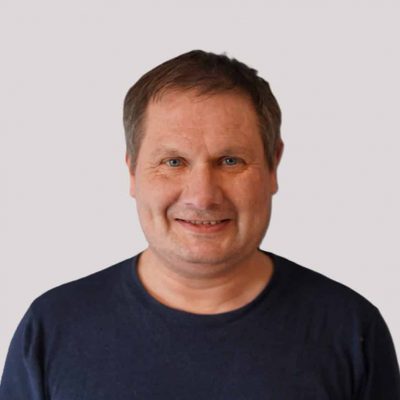 Person i svart genser som smiler mot kamera.