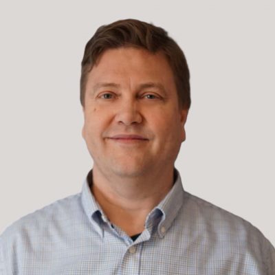 Modell av en profesjonell mann i forretningskontor, smilende, i skjorte.