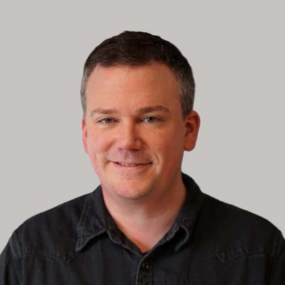 Profesjonell mann i svart skjorte smiler for kamera, portrettbilde, moderne fotografi.